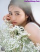 a woman holding a bunch of white flowers in her hand