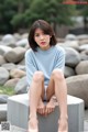 A woman sitting on top of a cement block.