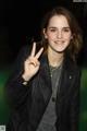 A woman in a black leather jacket making a peace sign.