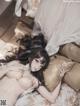 A woman laying on top of a bed next to pillows.