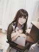 A girl sitting at a desk with her arms crossed.