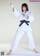 A woman in a white kimono with a black belt.