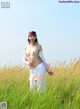 A woman standing in a field of tall grass.