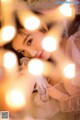 A woman laying on top of a bed covered in lights.