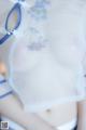 A woman wearing a white and blue lingerie with flowers on it.